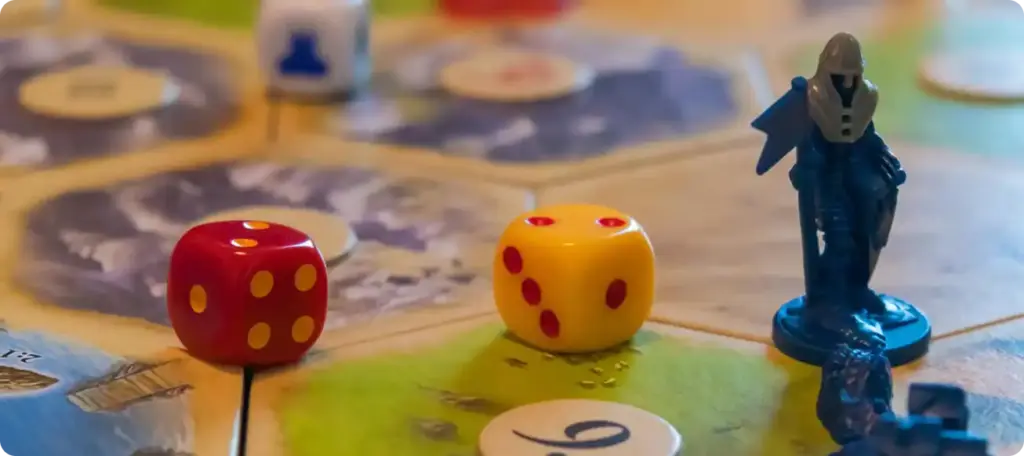 Close-up van dobbelstenen en fiches van spelers op een kleurrijk strategisch bordspel.